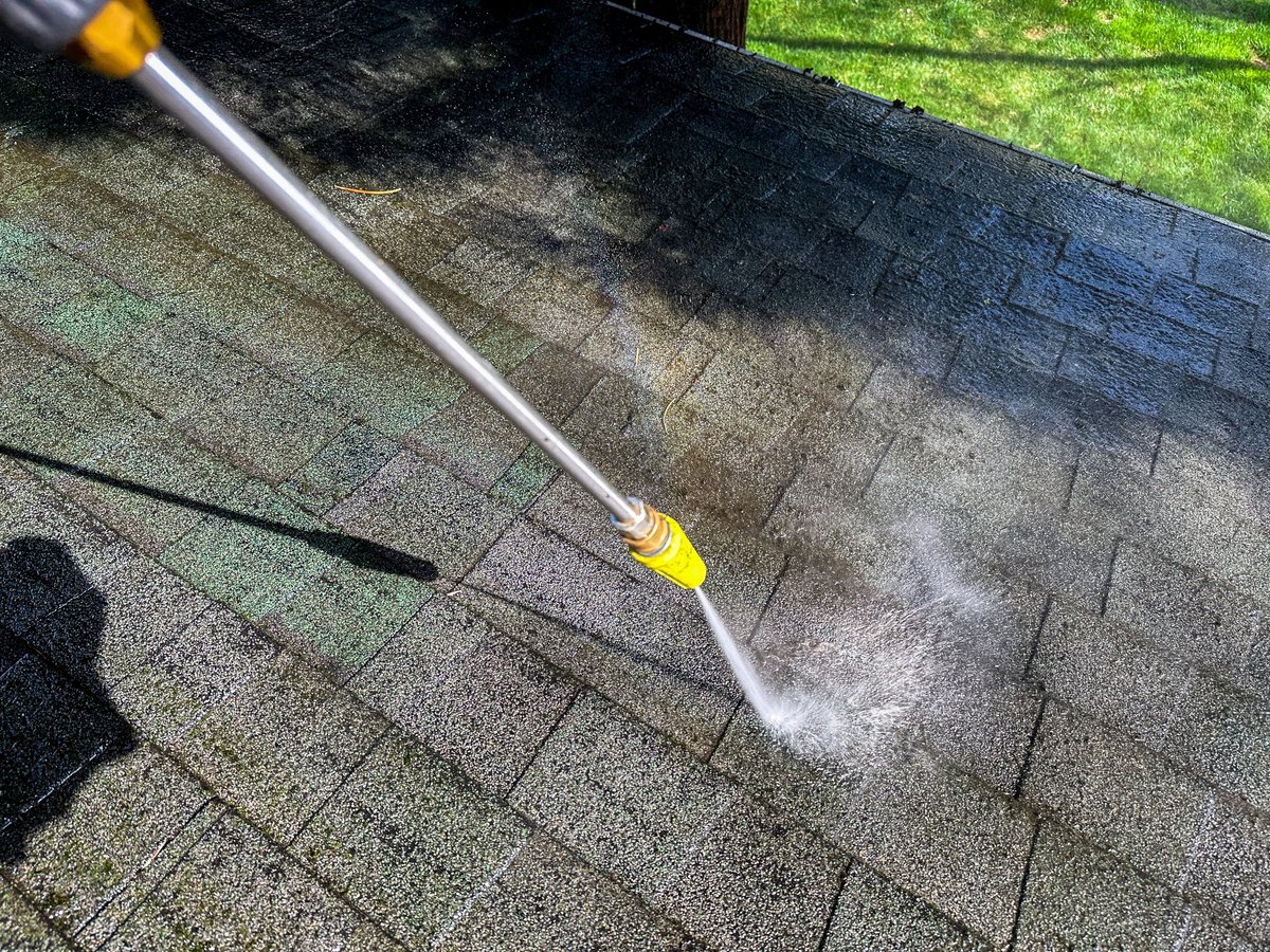 Soft washing a roof to remove dirt and debris from the shingles