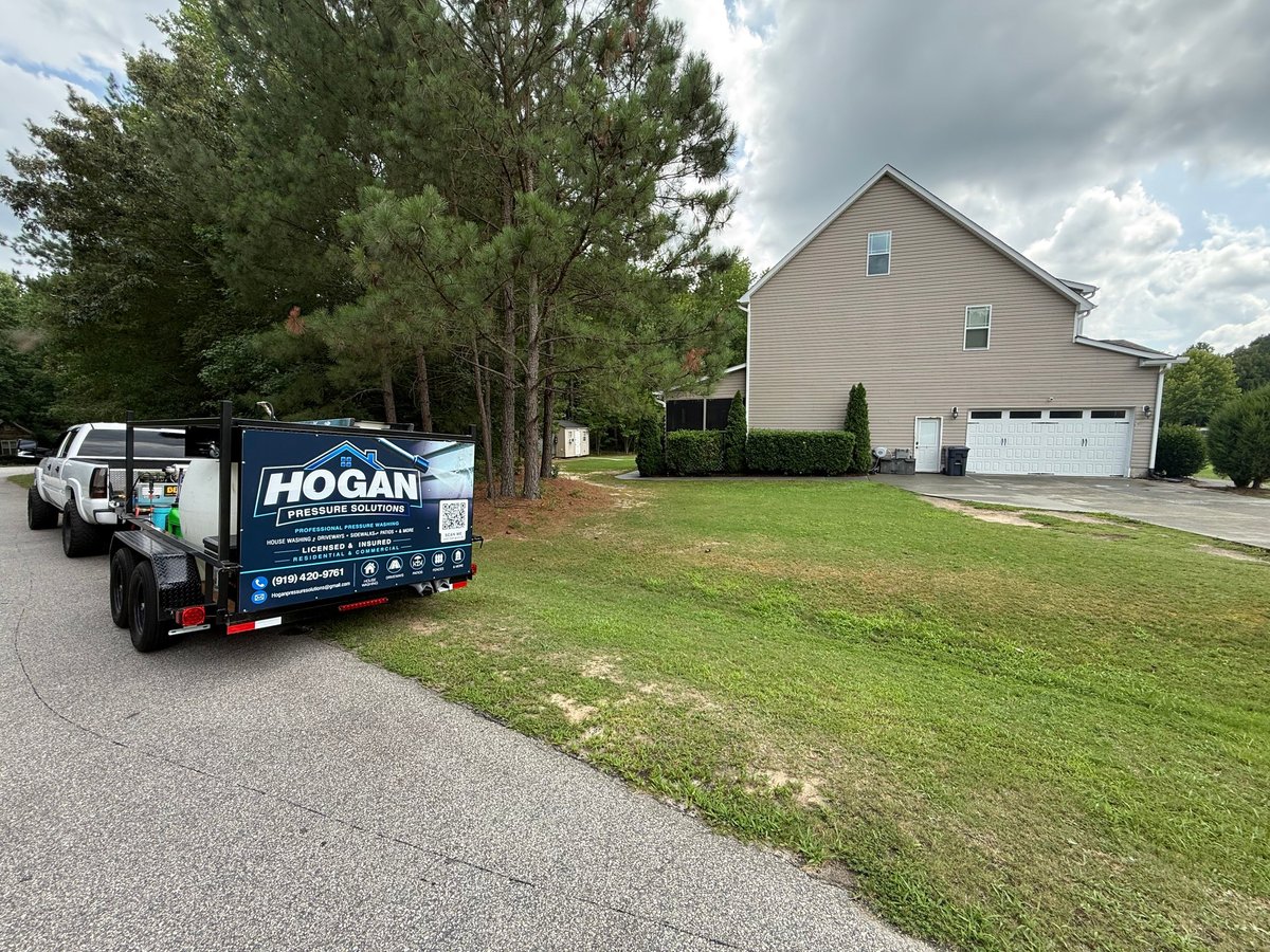 Hogan service truck parked in driveway of suburban home with two-car garage and large front lawn